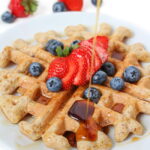 Plate of vegan gluten-free waffles with maple syrup