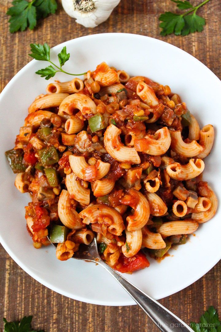 Overhead view of vegan goulash on a white serving plate with spoon