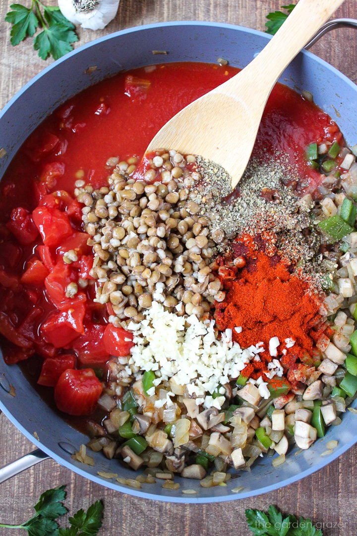 Overhead view of preparing ingredients in a large skillet before stirring together