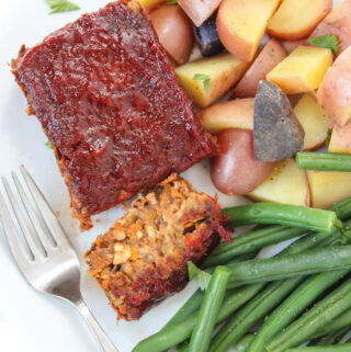 Vegan gluten-free meatloaf on a plate with green beans and potatoes