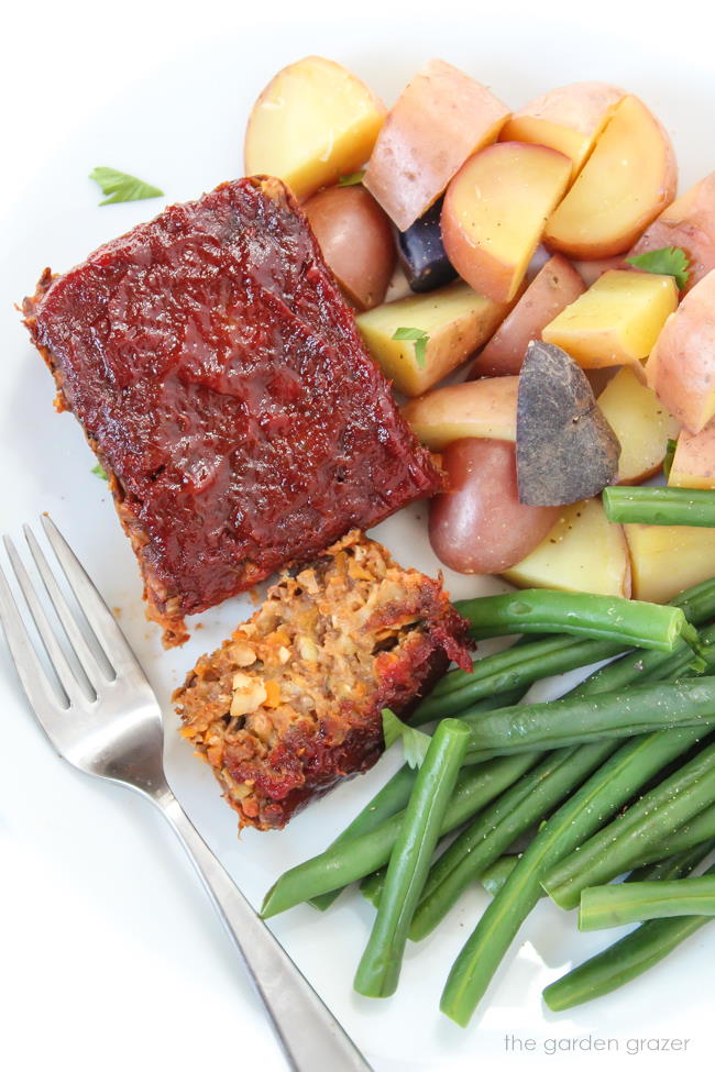 Vegan gluten-free meatloaf on a plate with green beans and potatoes