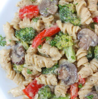 Plate of vegan creamy garlic pasta with broccoli and mushroom