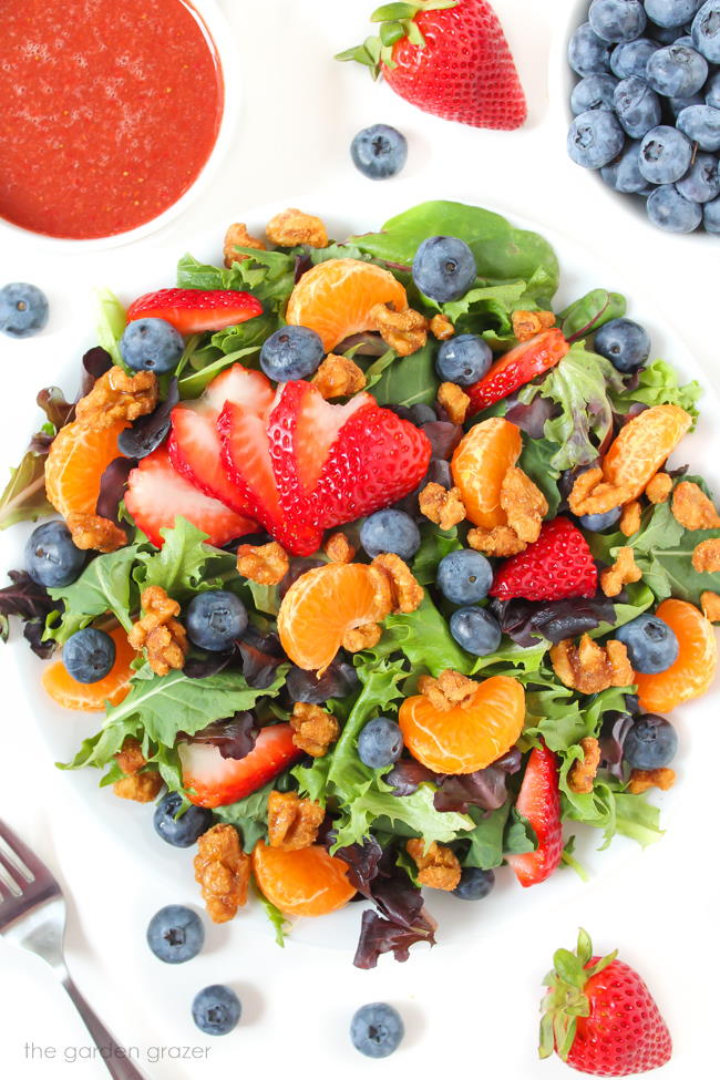 Berry salad with candied nuts on a white plate