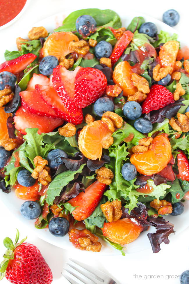 Plate of berry salad with candied nuts and strawberry balsamic dressing