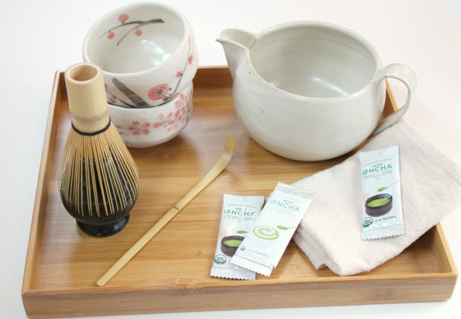 A bamboo tray with green tea tools and essentials