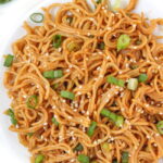 Vegan hoisin peanut butter noodles with sesame seeds on a white plate