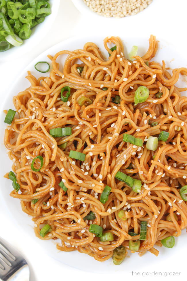 Vegan hoisin peanut butter noodles with sesame seeds on a white plate