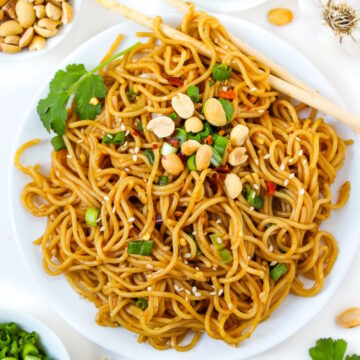 Hoisin peanut noodles on a white plate with chopsticks