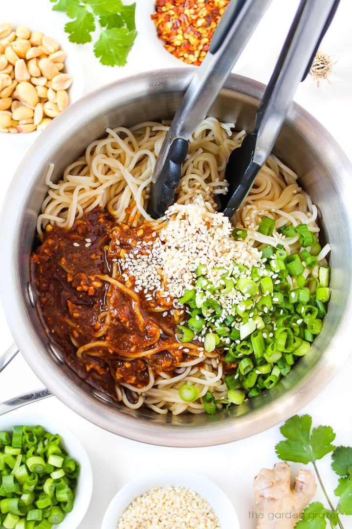 Overhead view of preparing hoisin noodles in a saucepan before stirring together