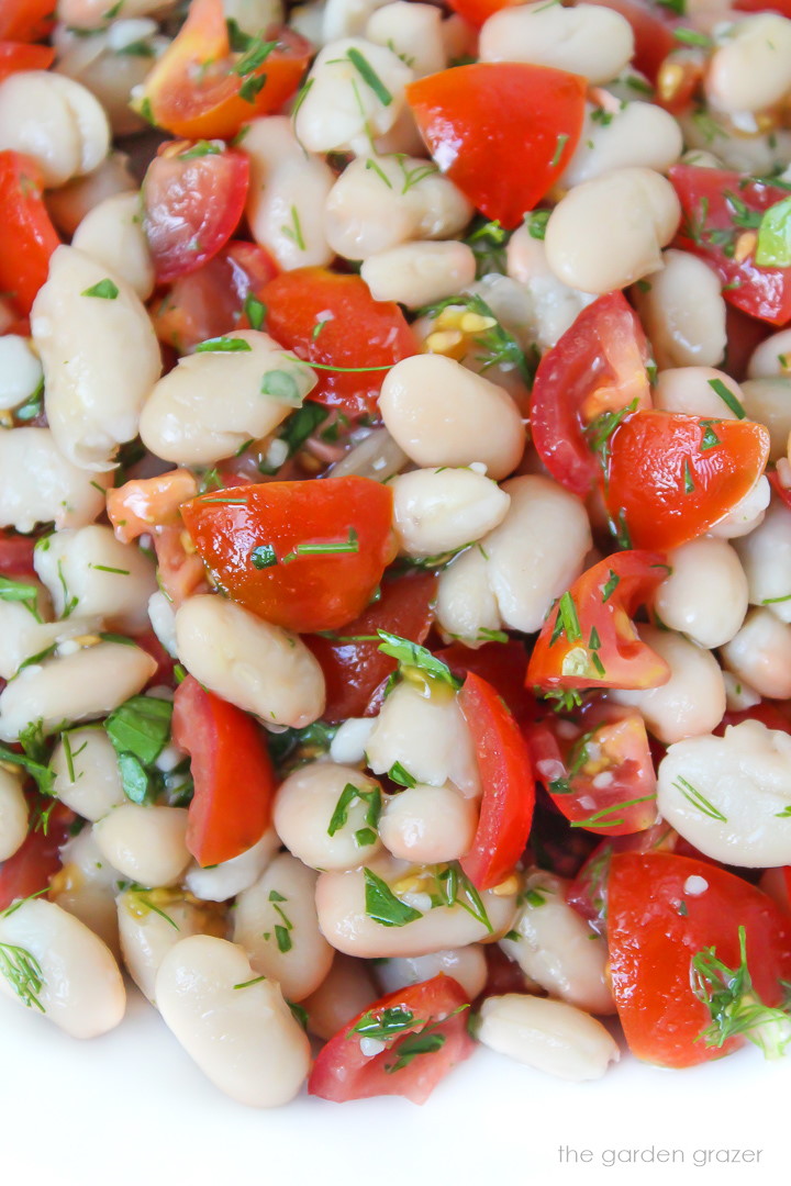 Close up view of white bean salad with herbs and tomatoes