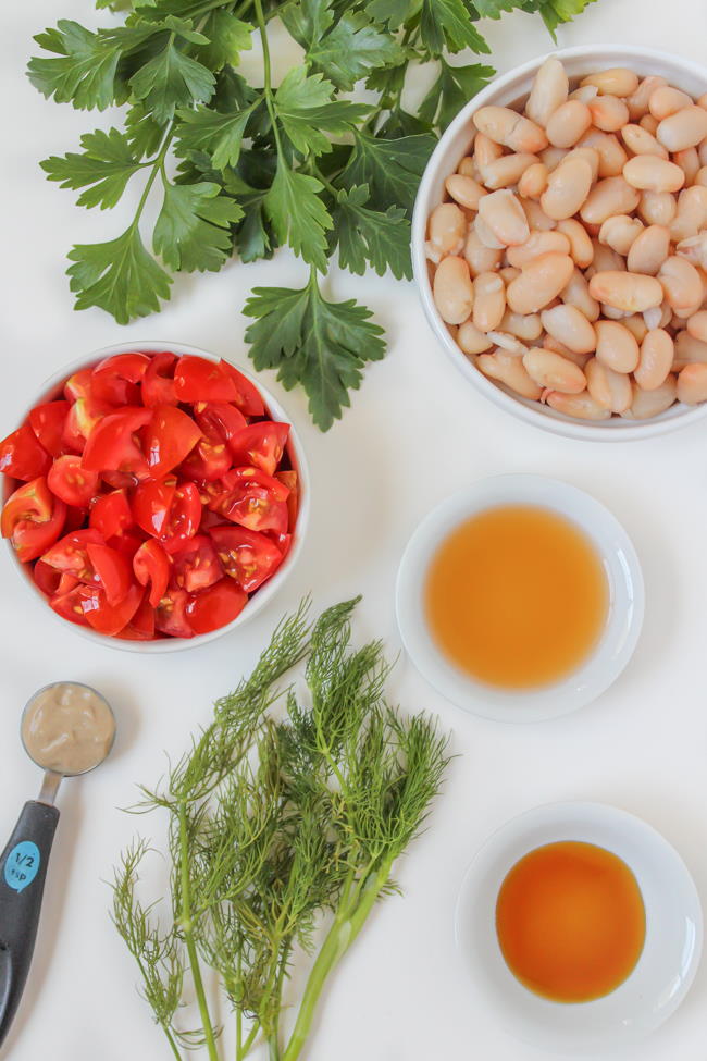 Ingredients on a table for white bean tomato salad recipe