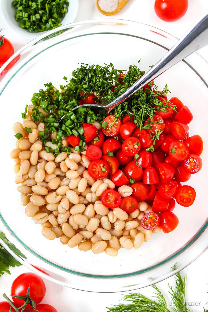 Overhead view of salad preparation in a large glass bowl