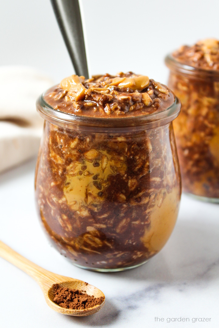 Vegan chunky monkey overnight oats in glass serving jars with spoon
