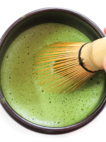 Whisking green tea in a black bowl