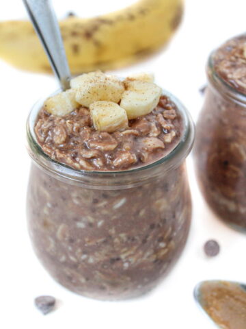 Small glass jar of chunky monkey overnight oats with spoon