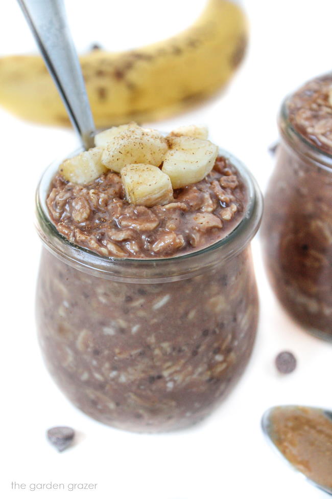 Small glass jar of chunky monkey overnight oats with spoon