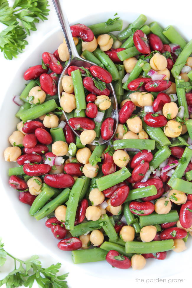 Three bean salad with oil-free vinegar dressing in a white bowl with spoon