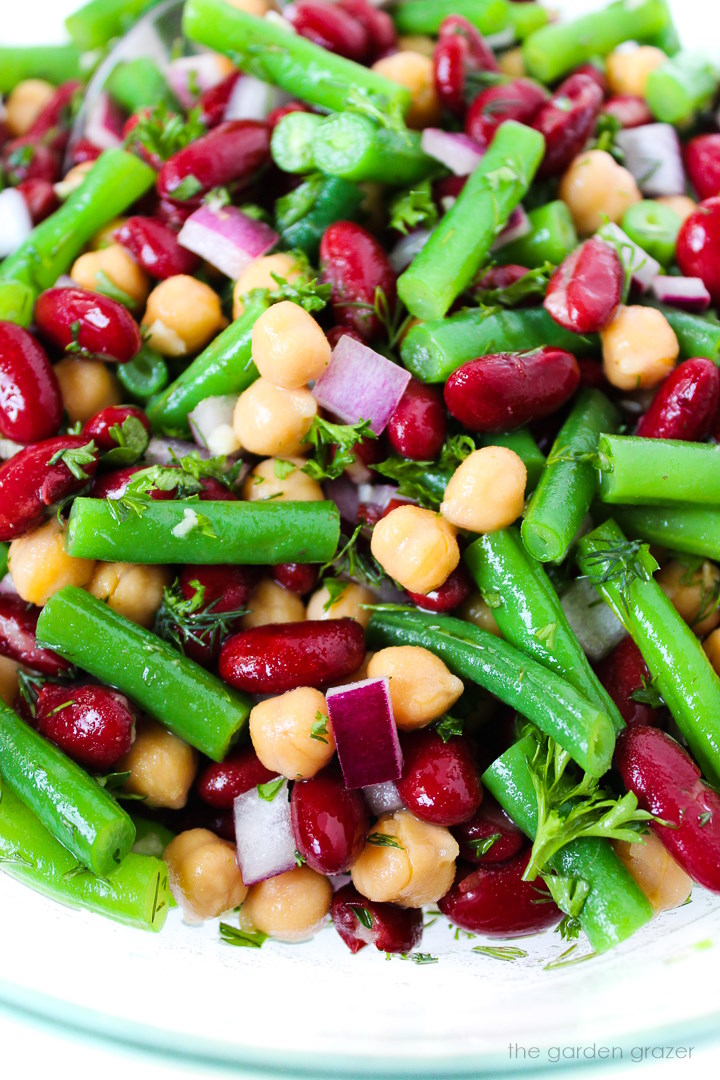 Close up view of three bean salad mixed together in a glass bowl