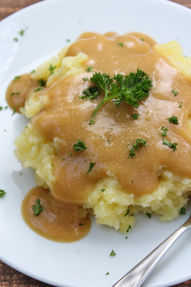 Mashed potatoes on a white plate with vegan oil free gravy on top