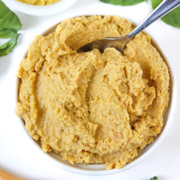 Vegan chickpea ricotta cheese in a white bowl with serving spoon