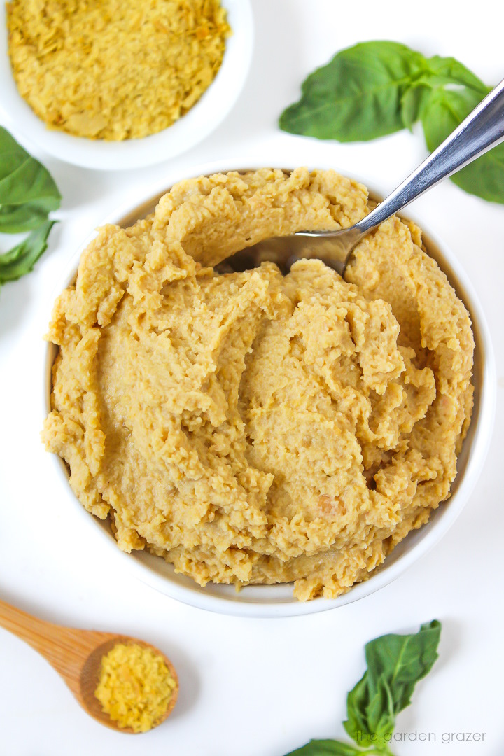 Vegan chickpea ricotta cheese in a white bowl with serving spoon