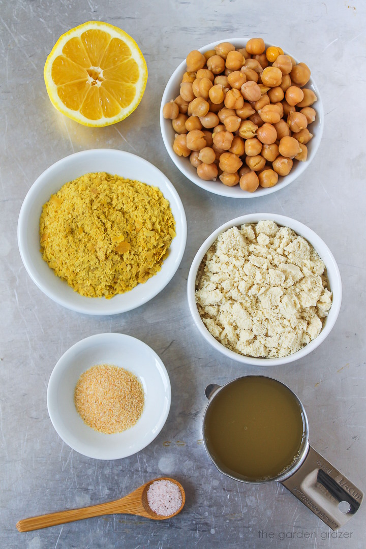 Garbanzo beans, almond flour, nutritional yeast, lemon, and seasoning ingredients laid out on a metal tray