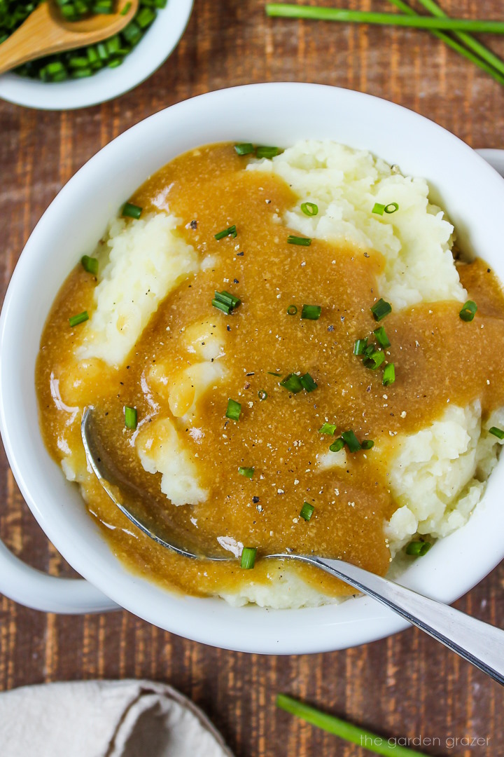 Close up view of easy vegan gravy on mashed potatoes in a white bowl