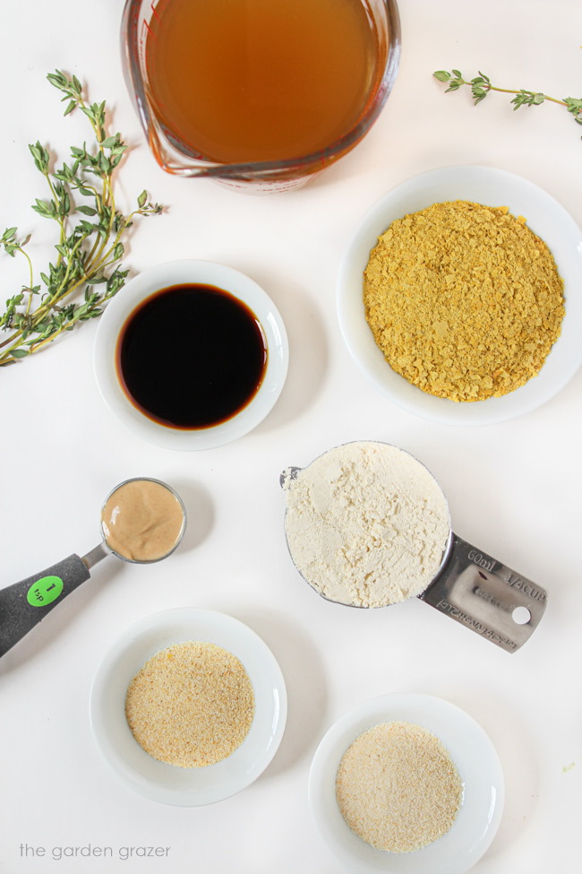 Broth, flour, mustard, tamari, and seasonings ingredients on a white table