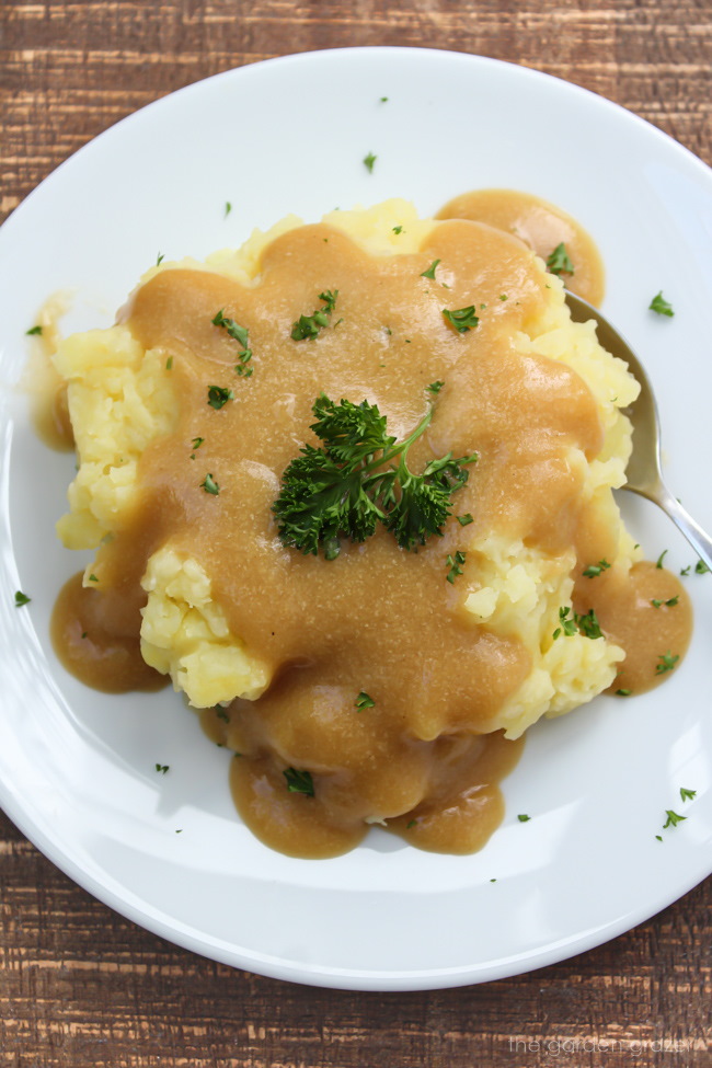 Mashed potatoes on a white plate with savory sauce on top