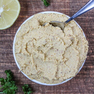 Vegan ricotta cheese in a small white bowl with spoon