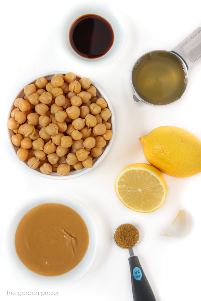 Ingredients for homemade hummus laid out on a white table