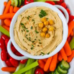 Overhead view of a veggie platter with a bowl of homemade oil-free hummus in the middle