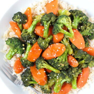 White bowl of vegan teriyaki broccoli and carrots with brown rice