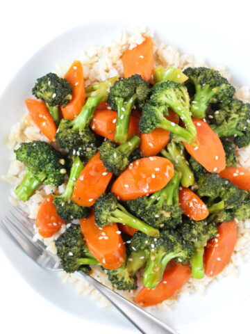 White bowl of vegan teriyaki broccoli and carrots with brown rice