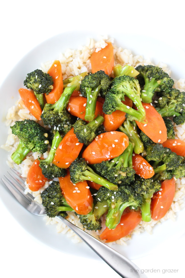 White bowl of vegan broccoli with sauce and brown rice