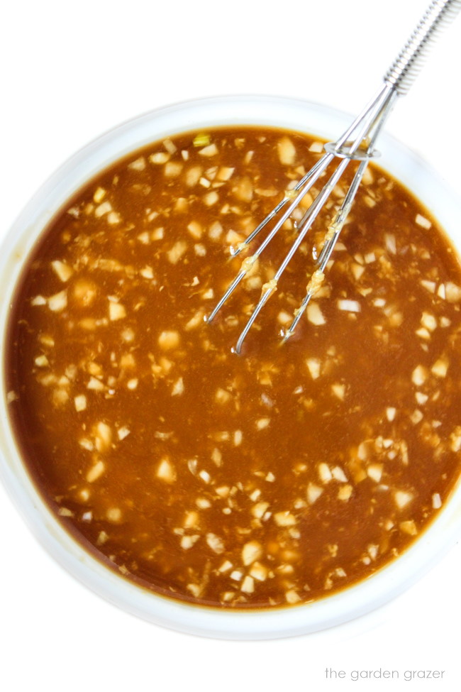 Preparing and whisking together teriyaki sauce in a small white bowl