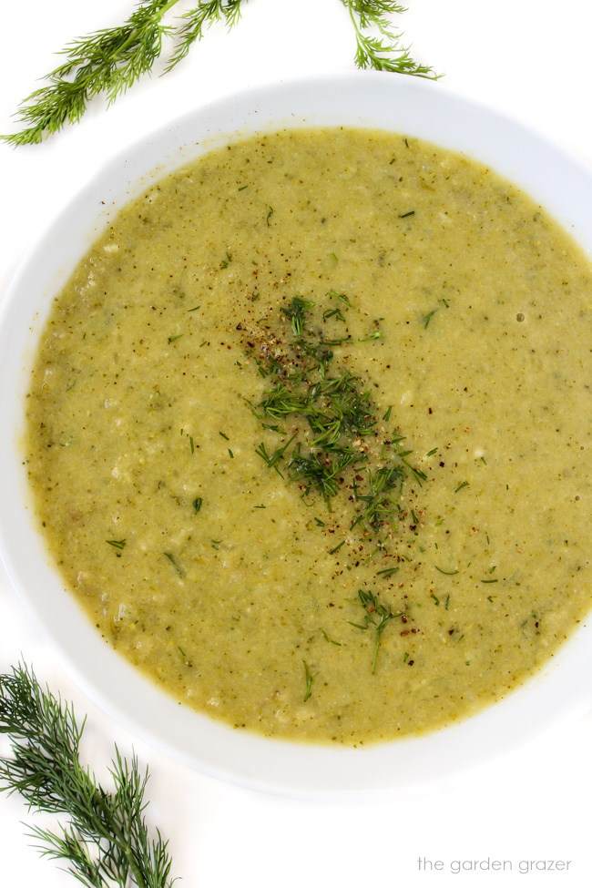 Healthy vegan broccoli potato soup in a white bowl with fresh dill