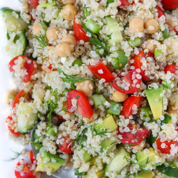 Quinoa Chickpea Salad with avocado and lemon dill dressing on a plate with spoon