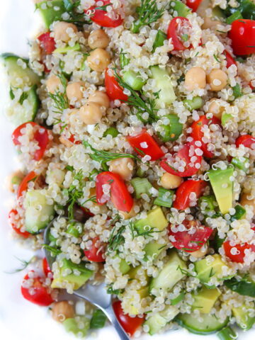 Quinoa Chickpea Salad with avocado and lemon dill dressing on a plate with spoon