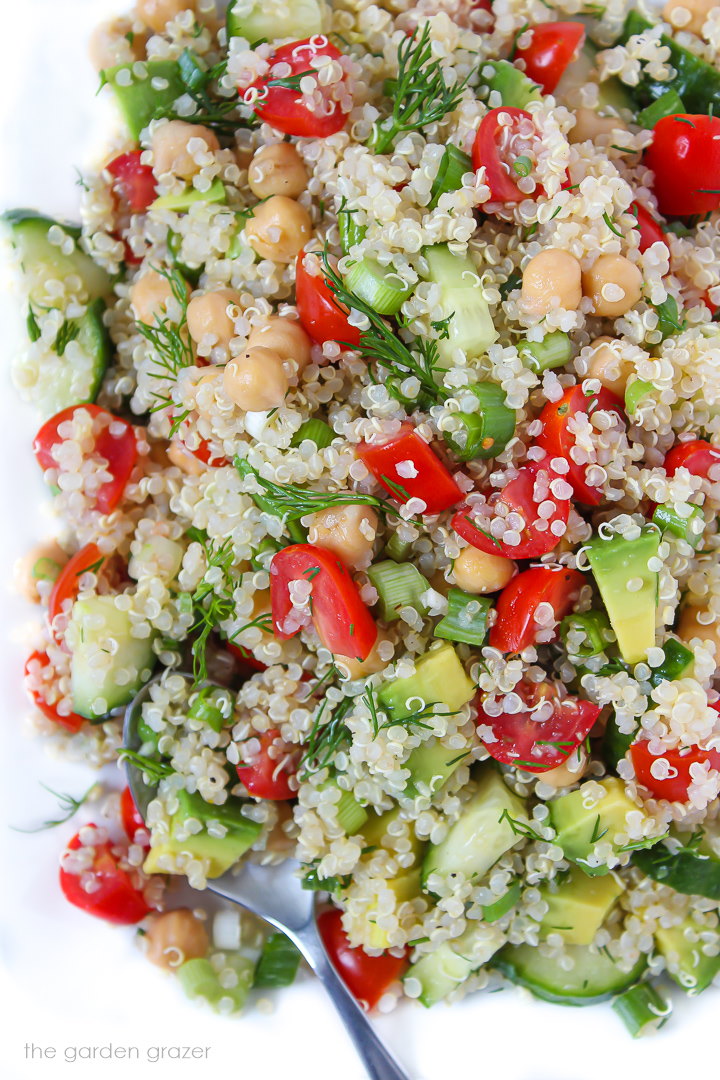 Quinoa Chickpea Salad with avocado and lemon dill dressing on a plate with spoon