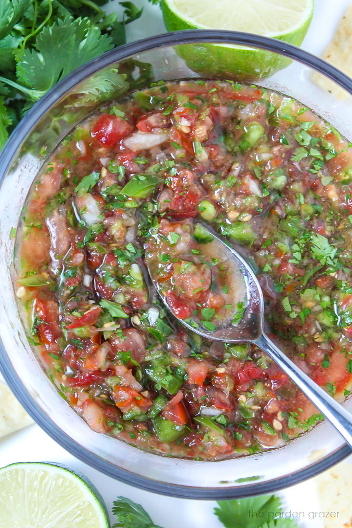 Fresh garden salsa in a glass bowl with serving spoon