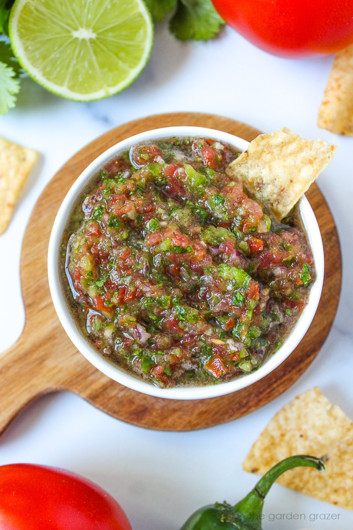 Overhead view of fresh garden salsa in a white serving bowl with tortilla chips