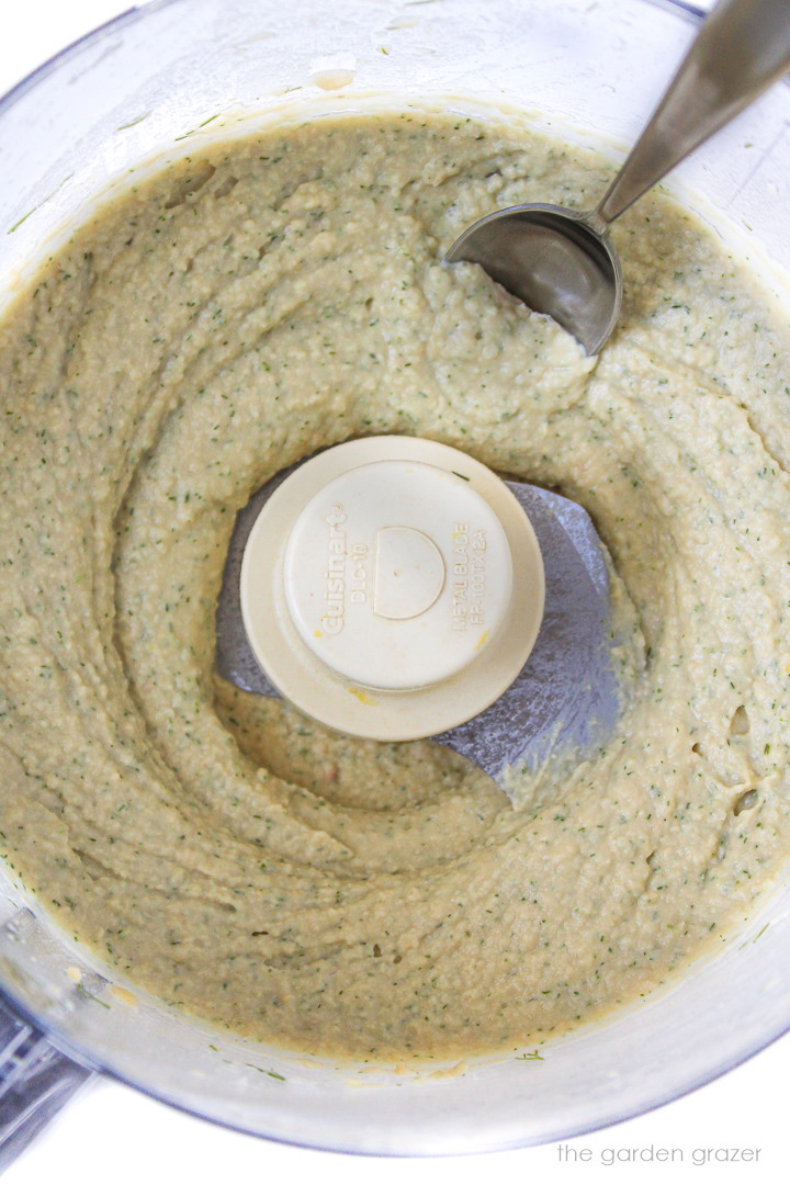 Overhead view of blended up lemon dill hummus in a food processor