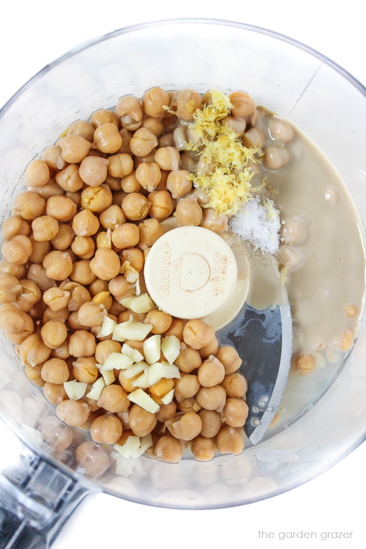 Overhead view of hummus ingredients in a food processor before blending together