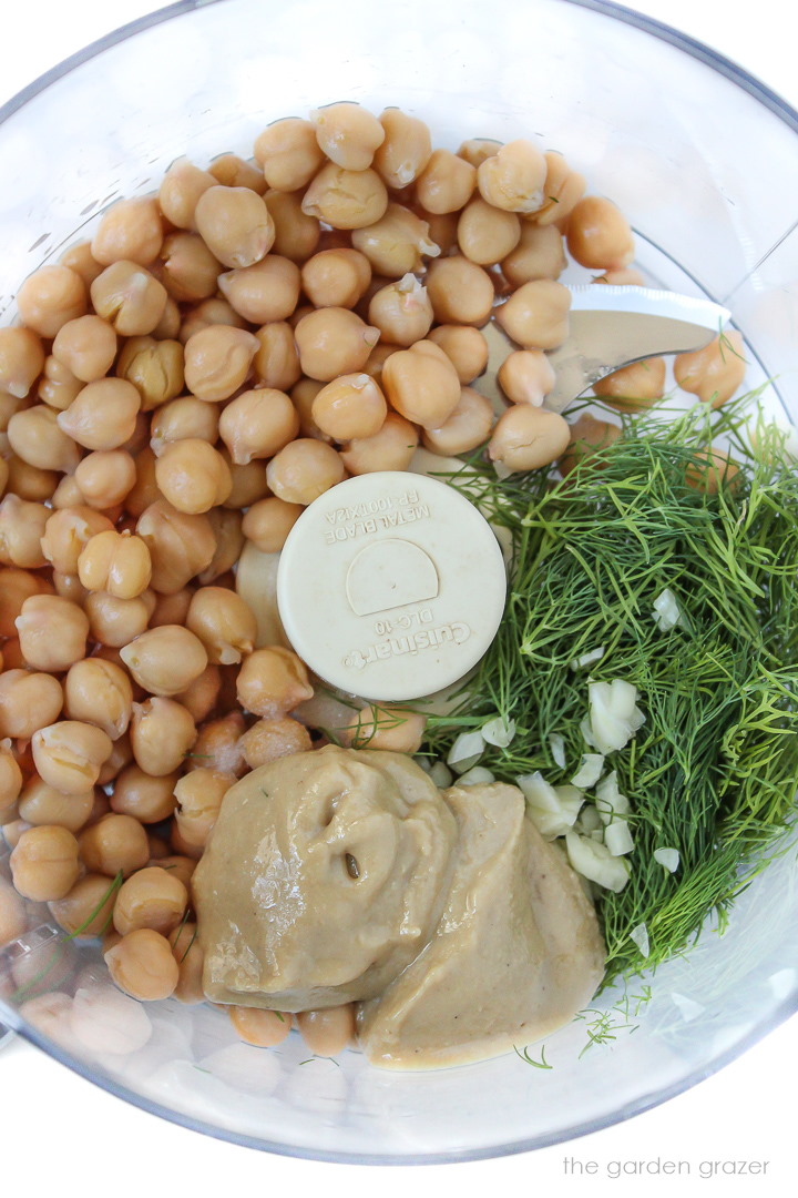 Chickpeas, tahini, dill, and garlic in a food processor before blending