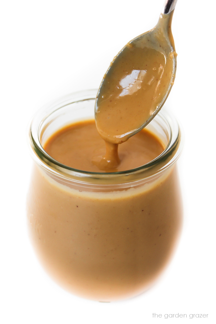 Peanut dressing in a small glass jar with spoon