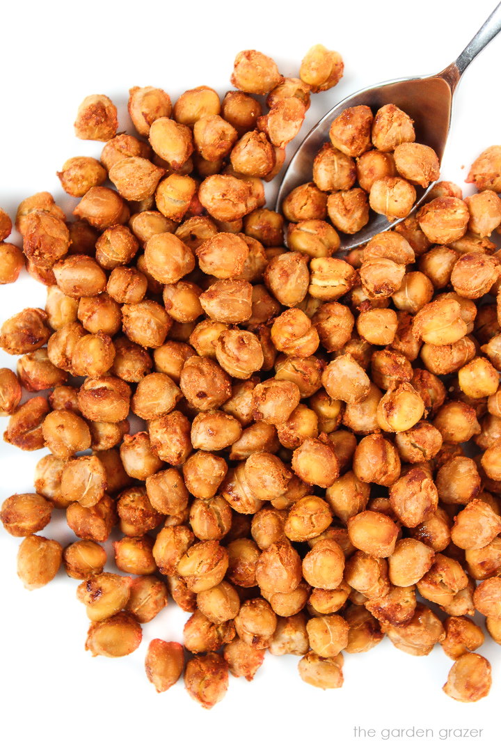 A metal spoon scooping up crispy smoky roasted chickpeas