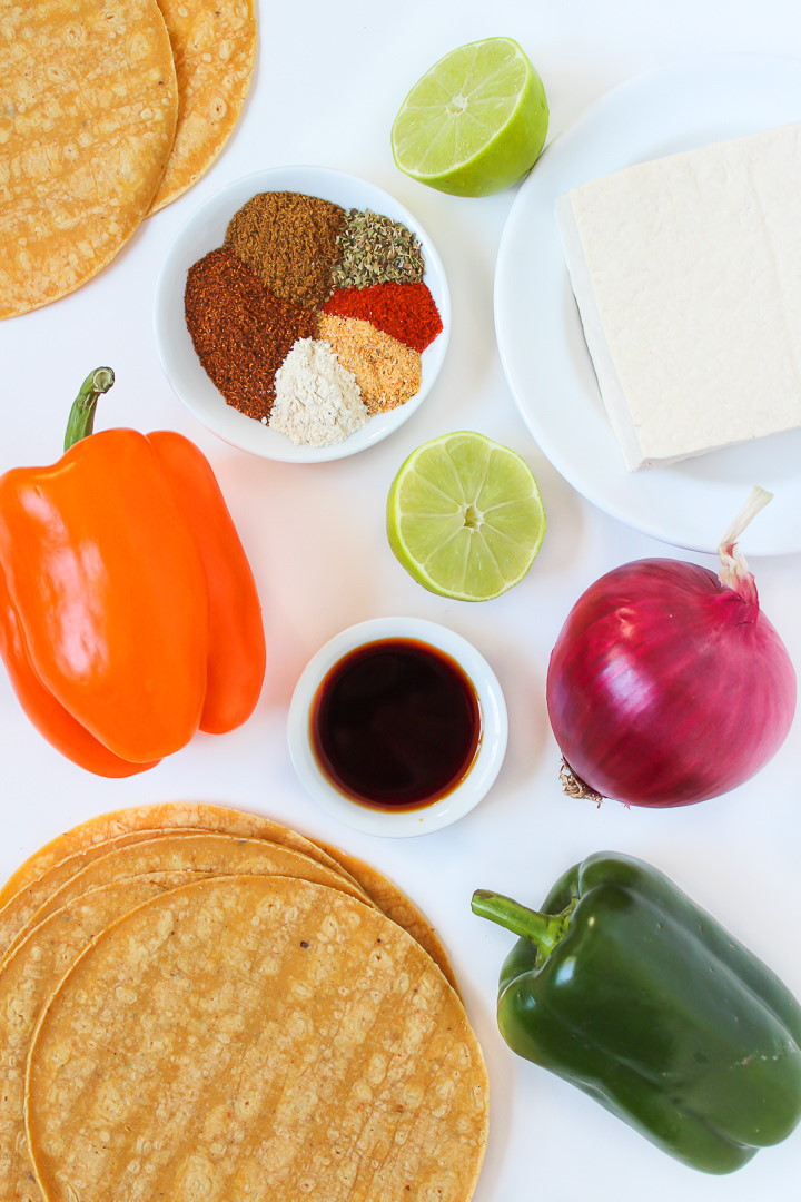 Ingredients for tofu fajitas laid out separately on a white table