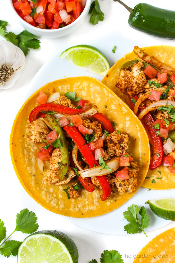 Vegan tofu fajitas on a white plate with lime wedge