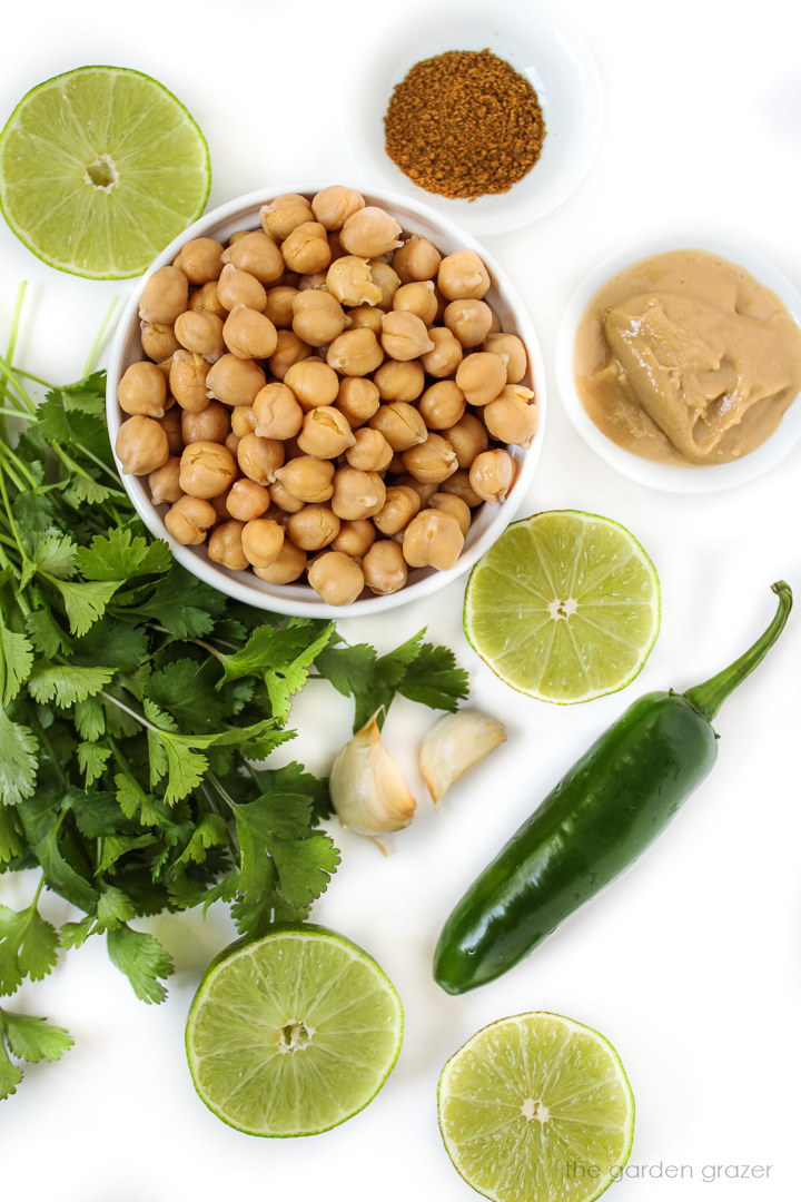 Fresh ingredients laid out on a white table for cilantro hummus